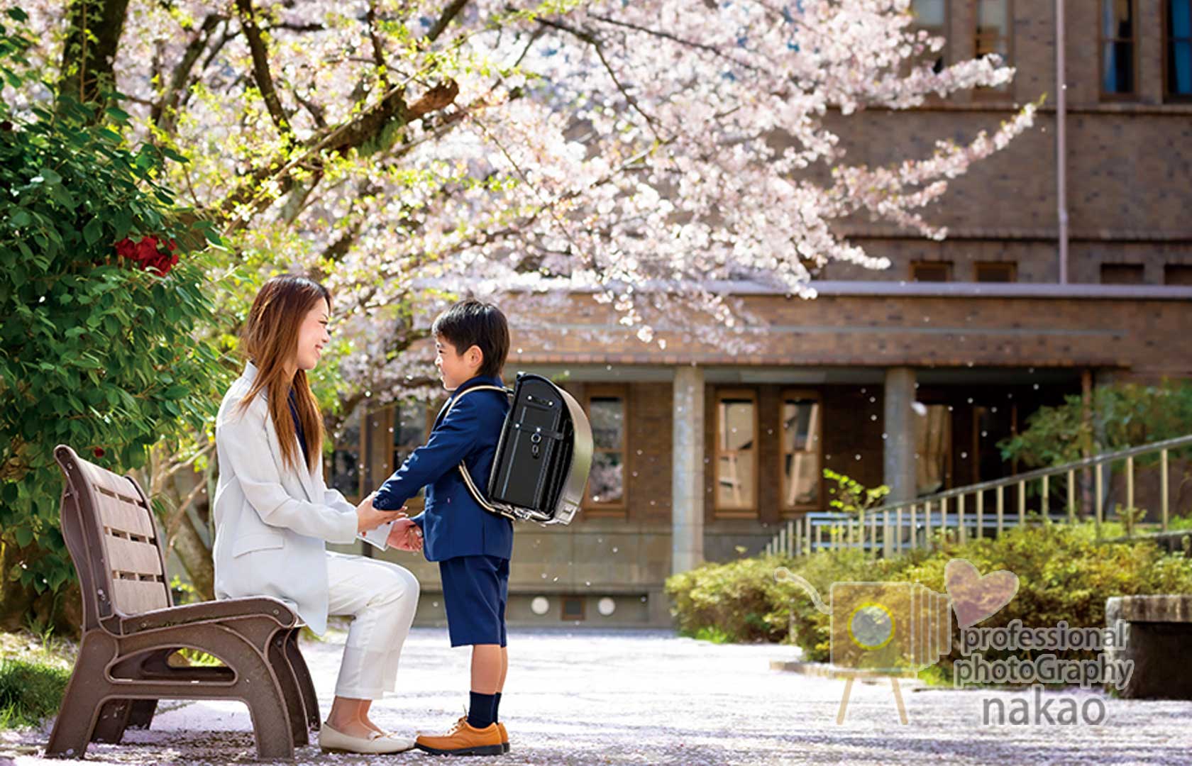桜の下で母と向き合う男の子、キラキラの新しいランドセル
