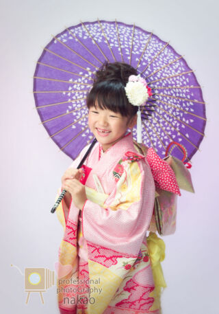 七五三 七つ祝いの女児、傘を肩に置いてにっこり